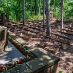 Szabadtéri misézőhely padokkal és virágágyással, fák ölelésében